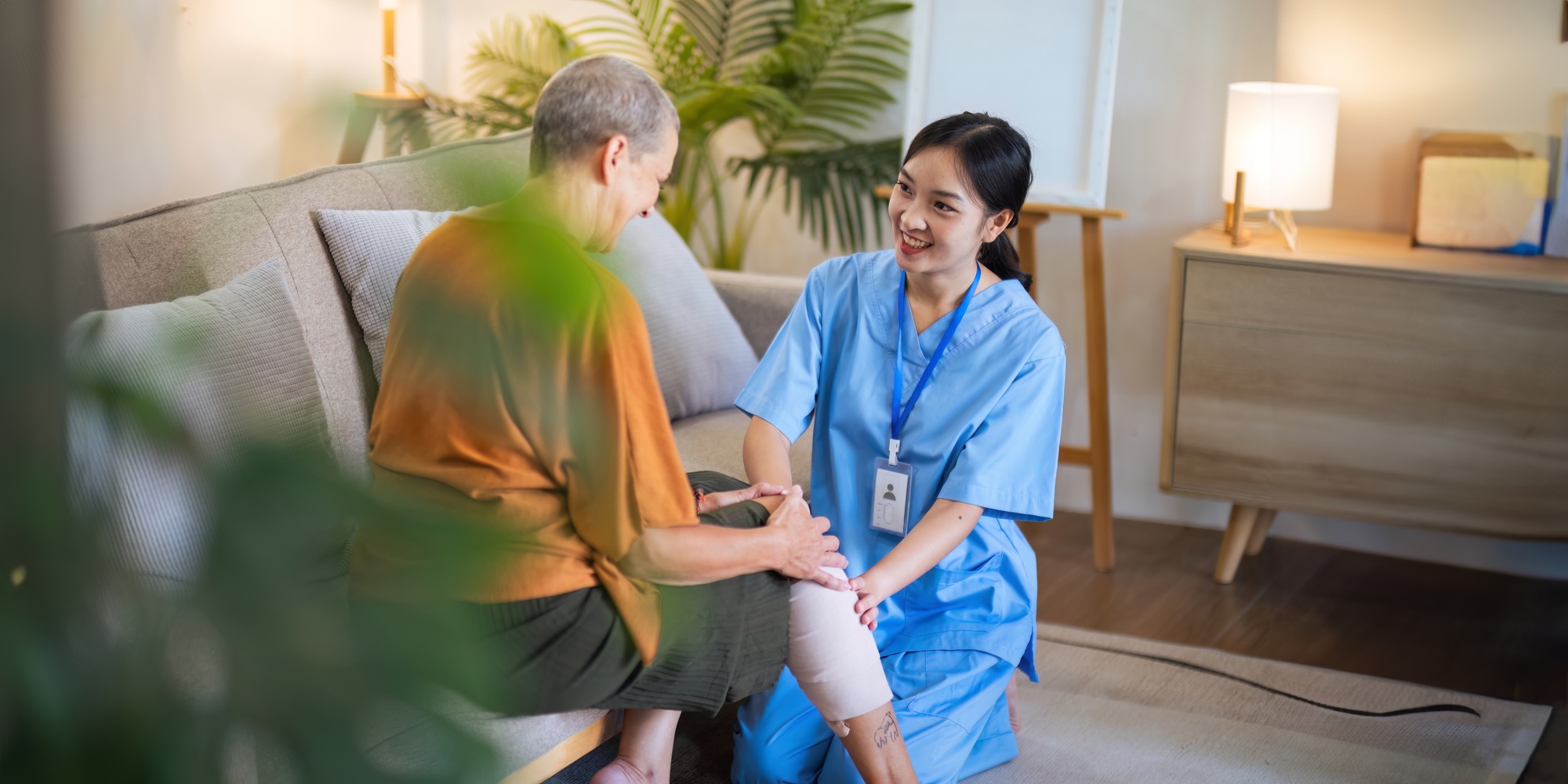 Physical therapist caregiver Asian and Caucasian senior women trust moving hand in rehabilitation